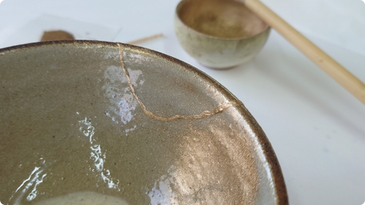 灰釉の炻器鉢を金継ぎで直した継ぎ目、奥に抹茶の茶碗