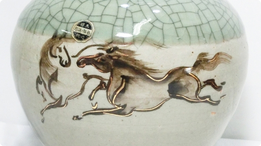 相馬焼の器。青磁色の肌に細かな青ひび貫入が走り、鉄絵と金線で描いた走り駒の絵が入る