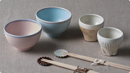 A pair chosen as a wedding gift: pink and pale blue rice bowls, two kohiki cups, flower-shaped chopstick rests and celebration chopsticks